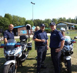 trzej policjanci stoją przy policyjnych motocyklach