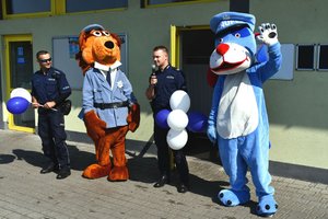 dwaj policjanci oraz maskotki śląskiej i mikołowskiej policji - Sznupek oraz Hektor