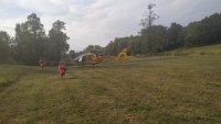 na zdjęciu widać helikopter lotniczego pogotowia ratunkowego oraz idące służby medyczne