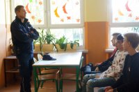dzielnicowy mł.asp. Łukasz Basa w trakcie spotkania profilaktycznego w szkole podstawowej w Mikołowie