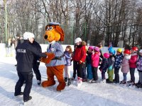 na zdjęciu: dzieci na lodowisku w Mikołowie, jeżdżą na łyżwach w towarzystwie sierżanta Hektora i policjantów