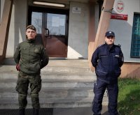 na zdjeciu: dzielnicowy z Mikołowa wraz z żołnierzem WOT przed wejściem do budynku komendy