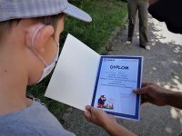 na zdjęciu: chłopiec odczytuje treść dyplomu, Mikołów