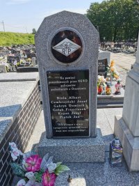 Na fotografii widać pomnik, na którym widnieje pamiątkowa tablica z nazwiskami pomordowanych policjantów