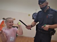 na zdjęciu: policjant wydziału prewencji wręcza dziecku odblask, spotkanie w placówce opiekuńczej urzędu miasta