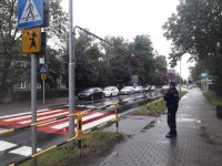 na zdjęciu: policjant stoi przed oznakowanym przejściem dla pieszych w centrum Łazisk Górnych