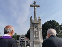 na zdjęciu widać fragment krzyża pomnika na cmentarzu w Ornontowicach, obok kapłan i jeden z uczestników uroczystości