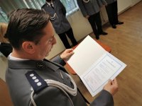 na zdjęciu: komendant powiatowy odczytuje akt ślubowania jednego z policjantów