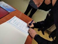 na zdjęciu: młody policjant podpisuje akt ślubowania