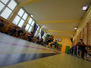 sala gimnastyczna, rozłożone ławki a wnich uczestnicy turnieju