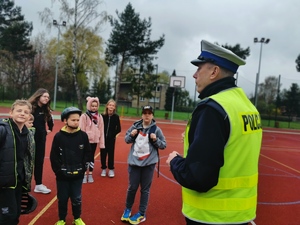 boisko szkolne, policjant rozmawia z uczniami