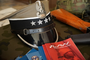 położona na stoliku wojskowa czapka, obok niej ulotki