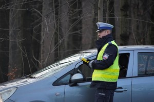 policjant drogówki podczas kontroli trzeźwości kierującego