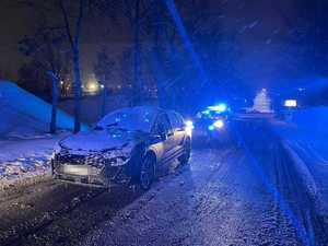 pora wieczorowa, zaśnieżona ulica, zaśnieżony samochód marki audi, za nim policyjny radiowóz
